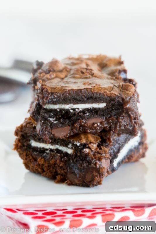 Fudgy Homemade Oreo Brownies stuffed with whole Oreo cookies for a rich, gooey, and crunchy dessert. Fudgy Oreo cookie brownies with a stack of Oreos