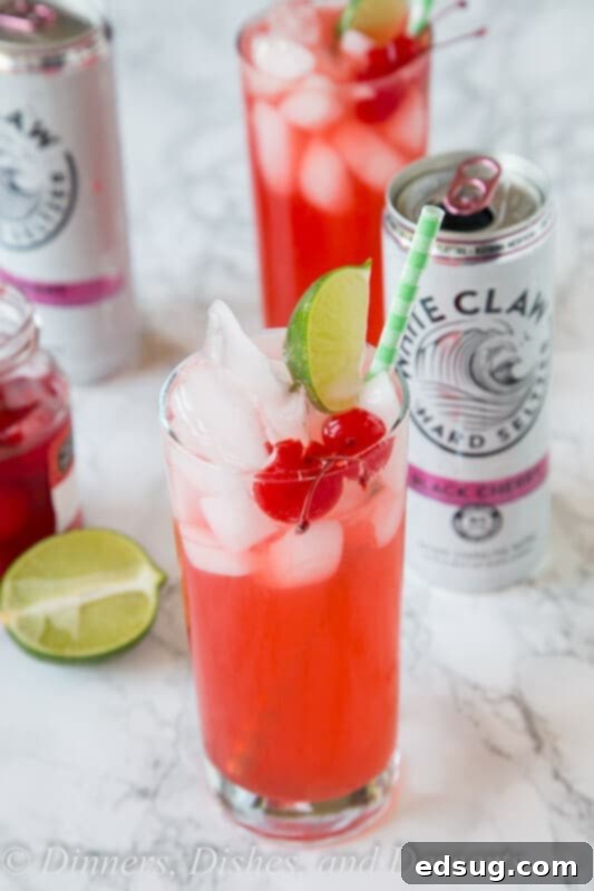 black cherry limeade in a cup with lime and cherry garnish