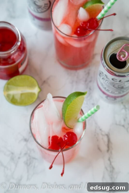 close up of black cherry limeade cocktail garnished with a lime wedge