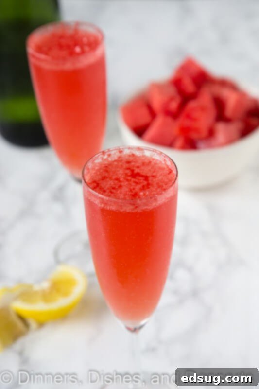 Close-up of a sparkling watermelon bellini in a champagne flute, garnished with a small watermelon slice