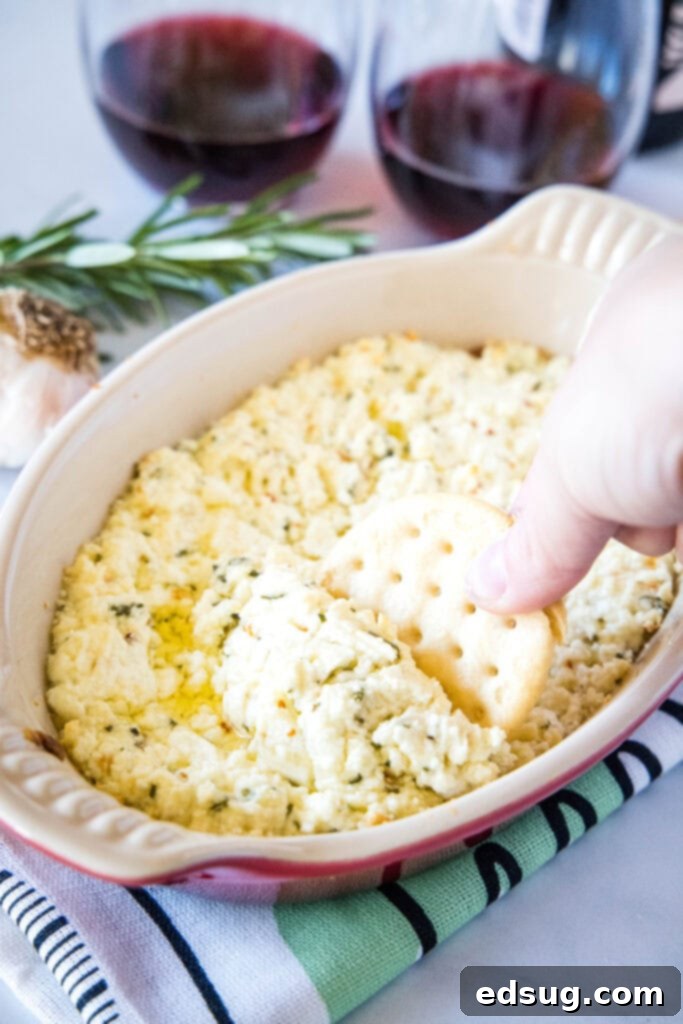 Warm, Tangy Goat Cheese Dip 2 scooping goat cheese dip out with a cracker