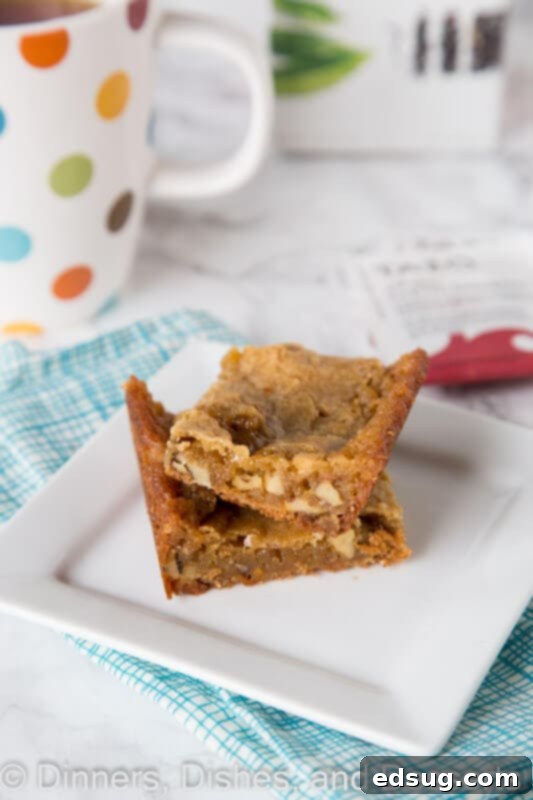 Golden Walnut Blondie Bliss 9 Walnut Blondie on a plate next to a steaming cup of Tazo tea, with whole walnuts scattered around