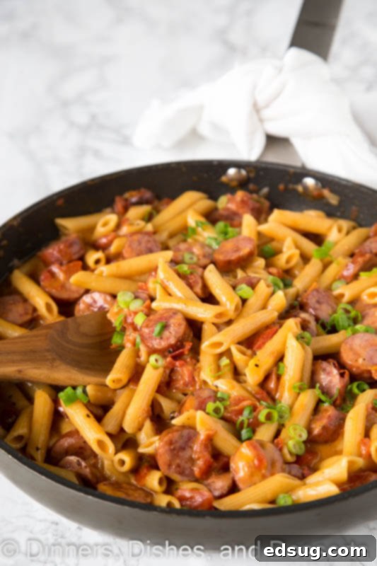 A pan filled with meat and vegetables, with Sausage and Pasta