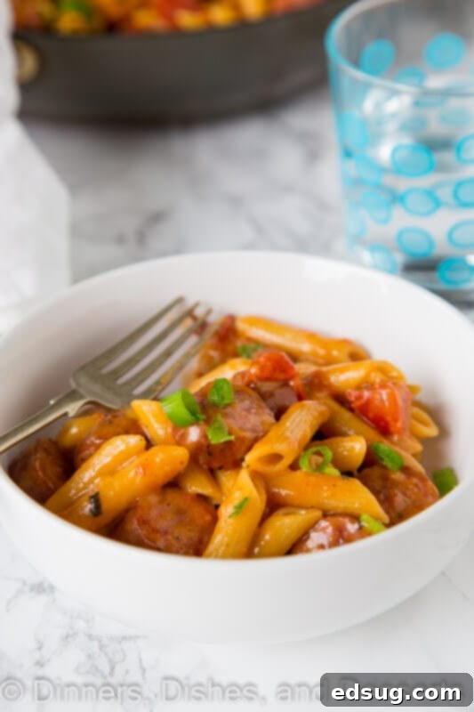 A bowl of food on a plate, with Sausage and Pasta