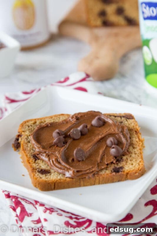 Peanut Butter Chocolate Chip Loaf 4 A single slice of peanut butter chocolate chip bread on a white plate, showcasing its texture