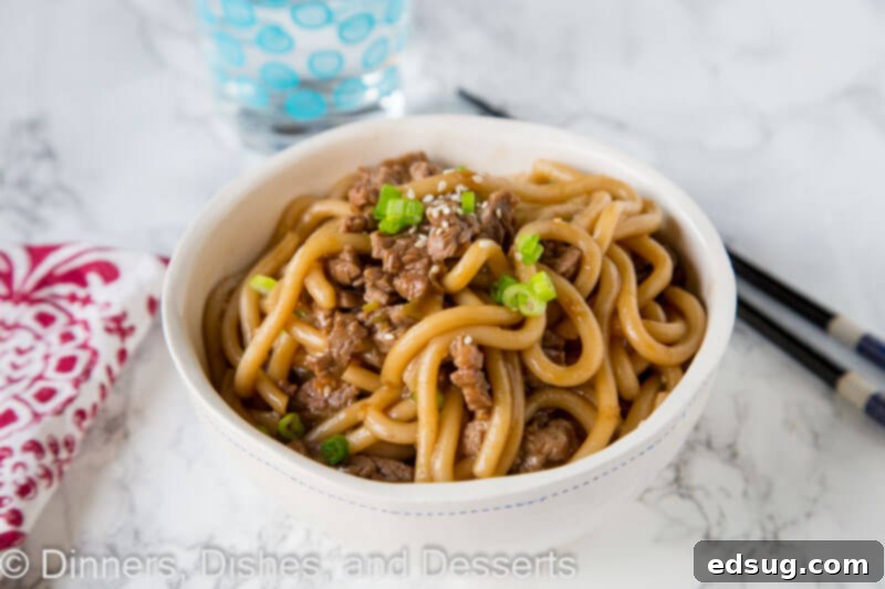 Garlicky Beef Noodle Bowls 3 A bowl of Garlic Beef Noodles garnished with green onions and sesame seeds