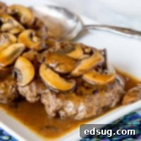Hamburger Steaks with Mushroom Gravy - easy comfort food that won't break the bank! Rich mushroom gravy over tender hamburger steaks is a great weeknight dinner.