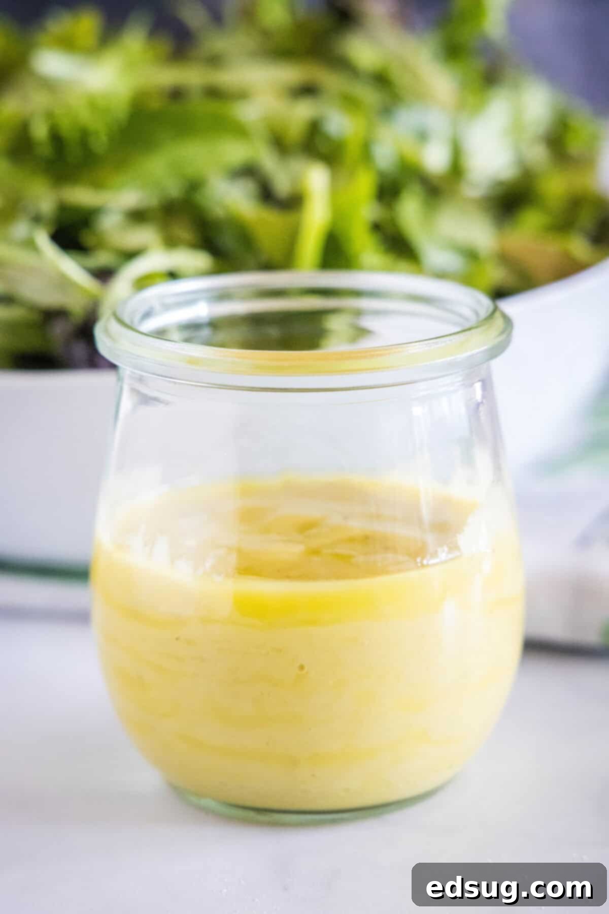 Homemade roasted garlic vinaigrette served in a small glass jar, garnished for presentation