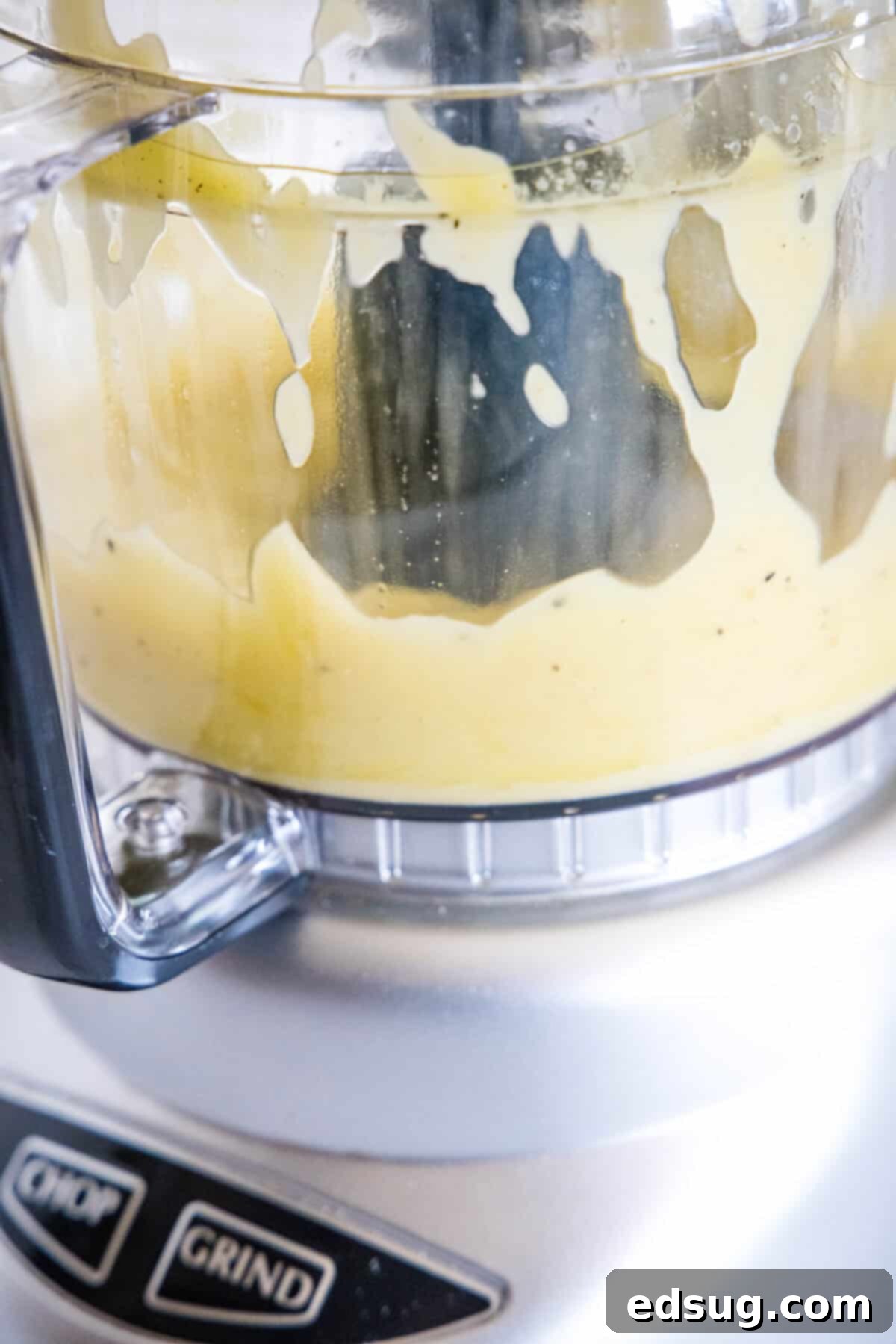 The vibrant roasted garlic dressing being blended to perfection in a food processor