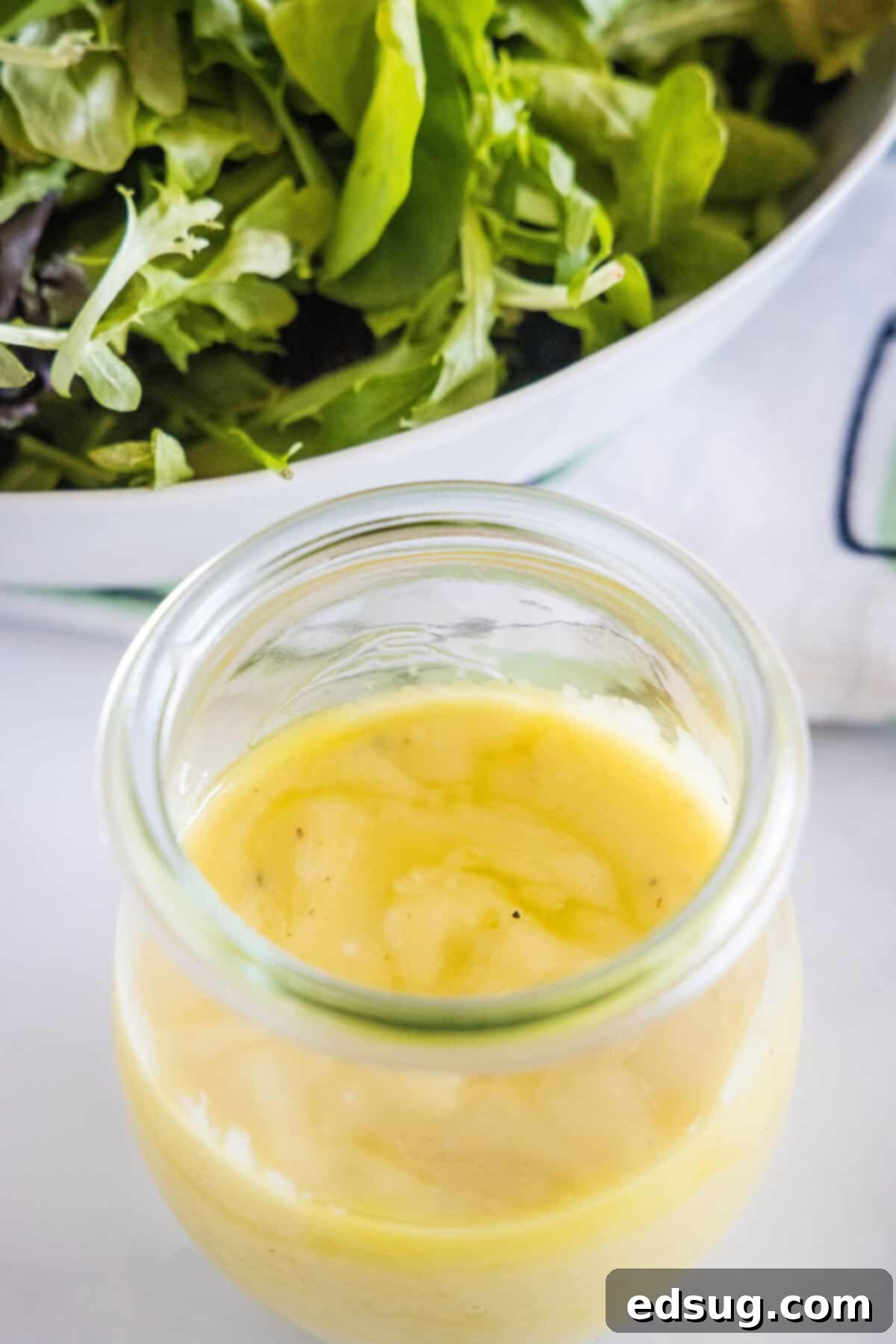 Top-down view of a glass jar filled with luscious roasted garlic vinaigrette, ready to be served