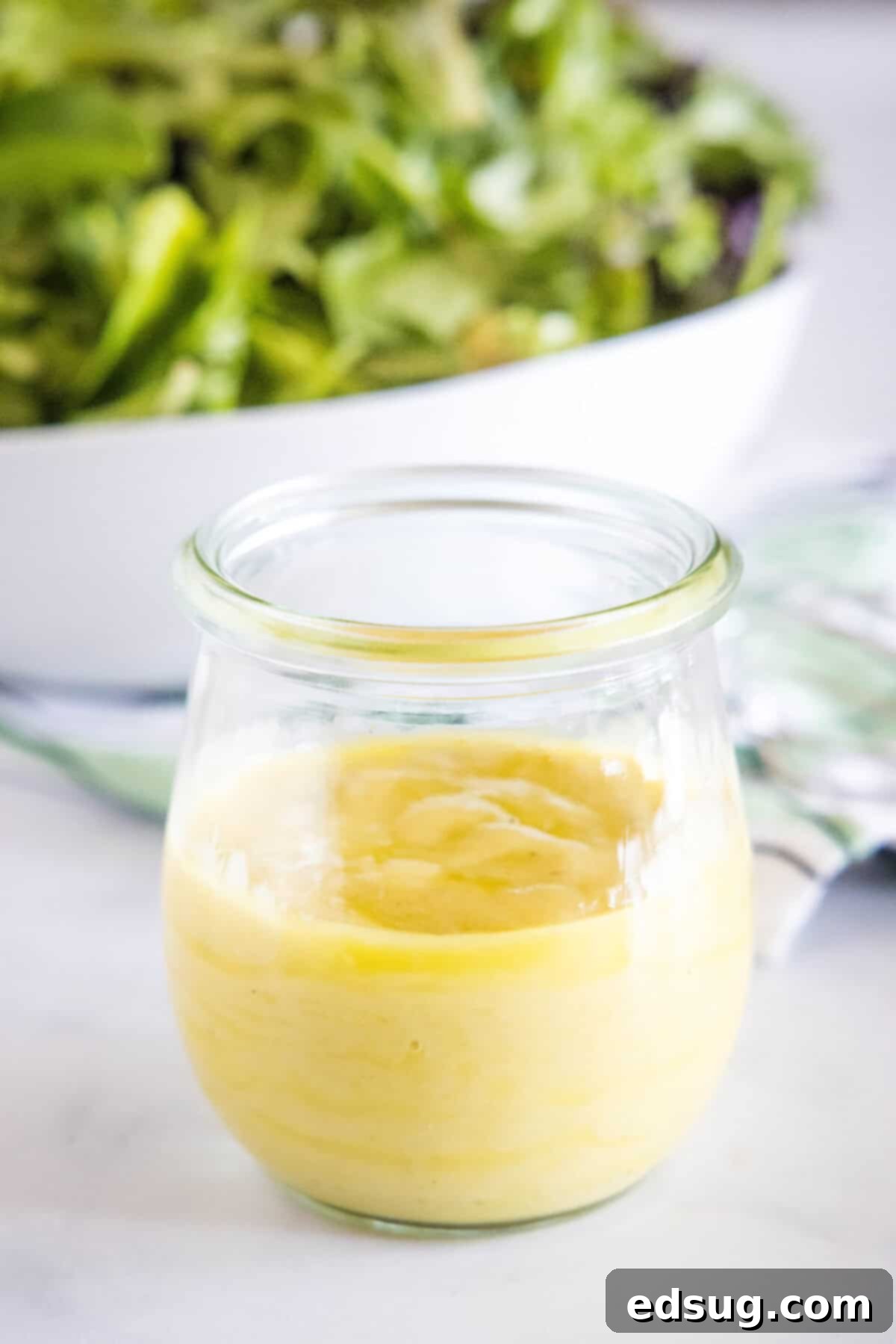 A pristine glass jar showcasing a fresh batch of homemade roasted garlic vinaigrette