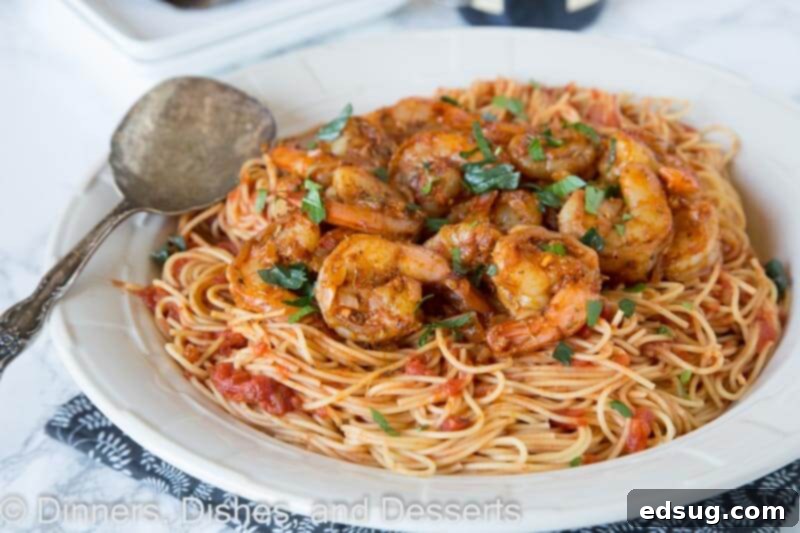 Cajun Blackened Shrimp Pasta 3 A close-up of blackened shrimp pasta in a skillet, ready to be served, showing the rich sauce and pasta strands.