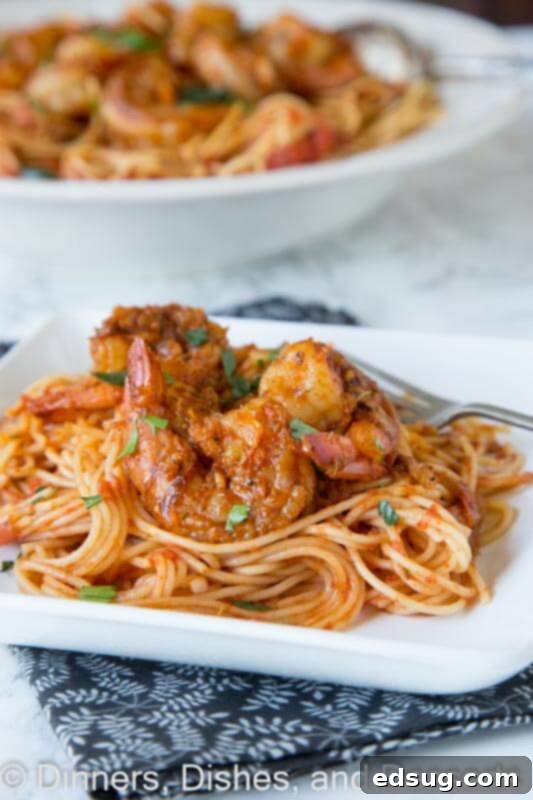 Cajun Blackened Shrimp Pasta 4 A serving of blackened shrimp pasta topped with fresh parsley, ready to be enjoyed.