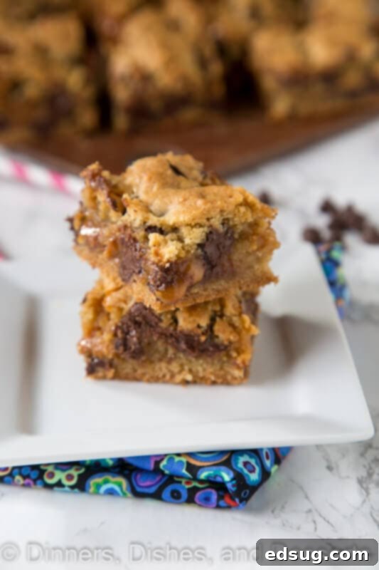 Close-up of freshly baked chocolate chip caramel cookie bars on a plate, showing the gooey caramel and melted chocolate chips.