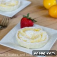 mini lemon tart on a white plate with lemons in the background