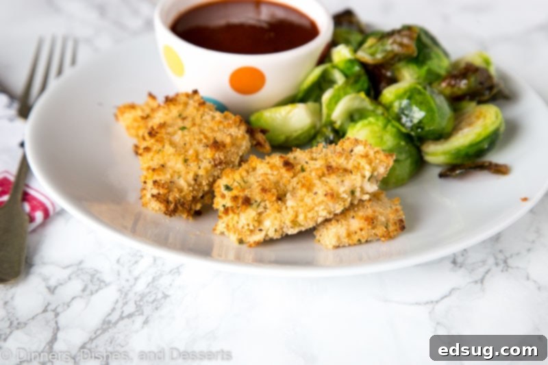 Adult Essentials 3 A close-up shot of several homemade chicken nuggets perfectly golden and crispy on a plate, with a bowl of barbecue sauce in the background.
