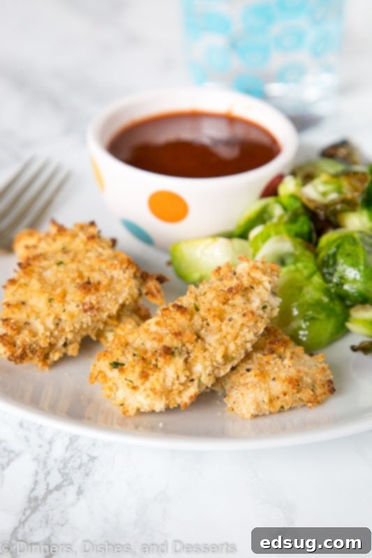 Adult Essentials 4 A beautifully arranged plate of homemade crispy chicken nuggets with various dipping sauces like BBQ and honey mustard, alongside a sprig of fresh rosemary.