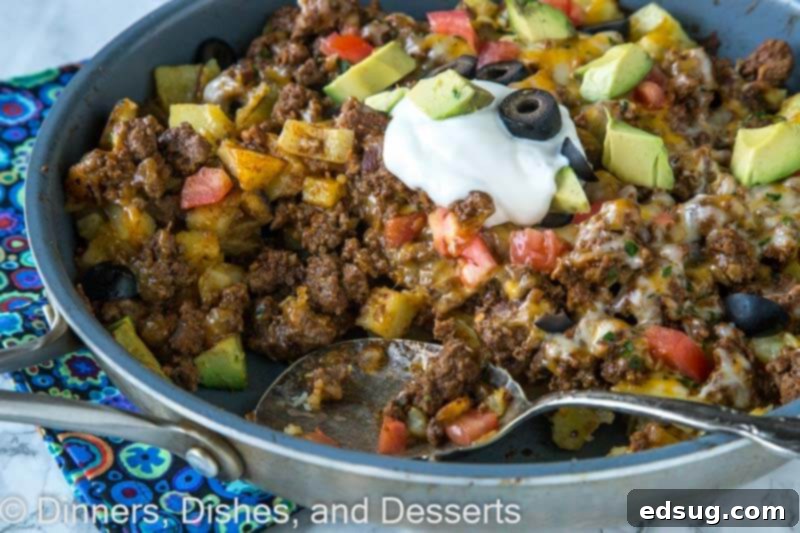 A close-up of Mexican skillet potatoes with melted cheese and fresh cilantro garnish, showcasing the delicious textures.