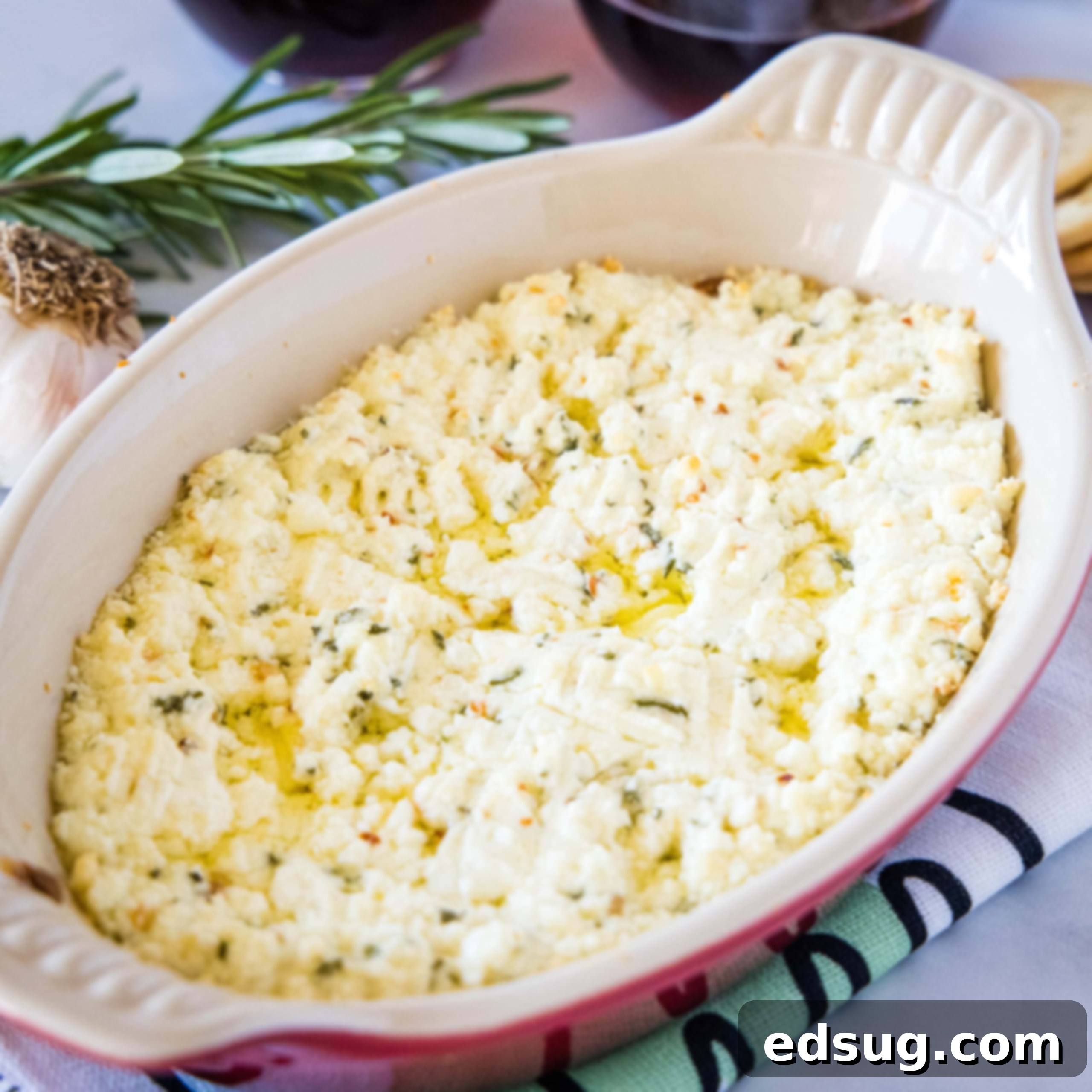 Kickoff Comfort Food 12 Cropped in close-up of baked goat cheese dip, garnished with herbs