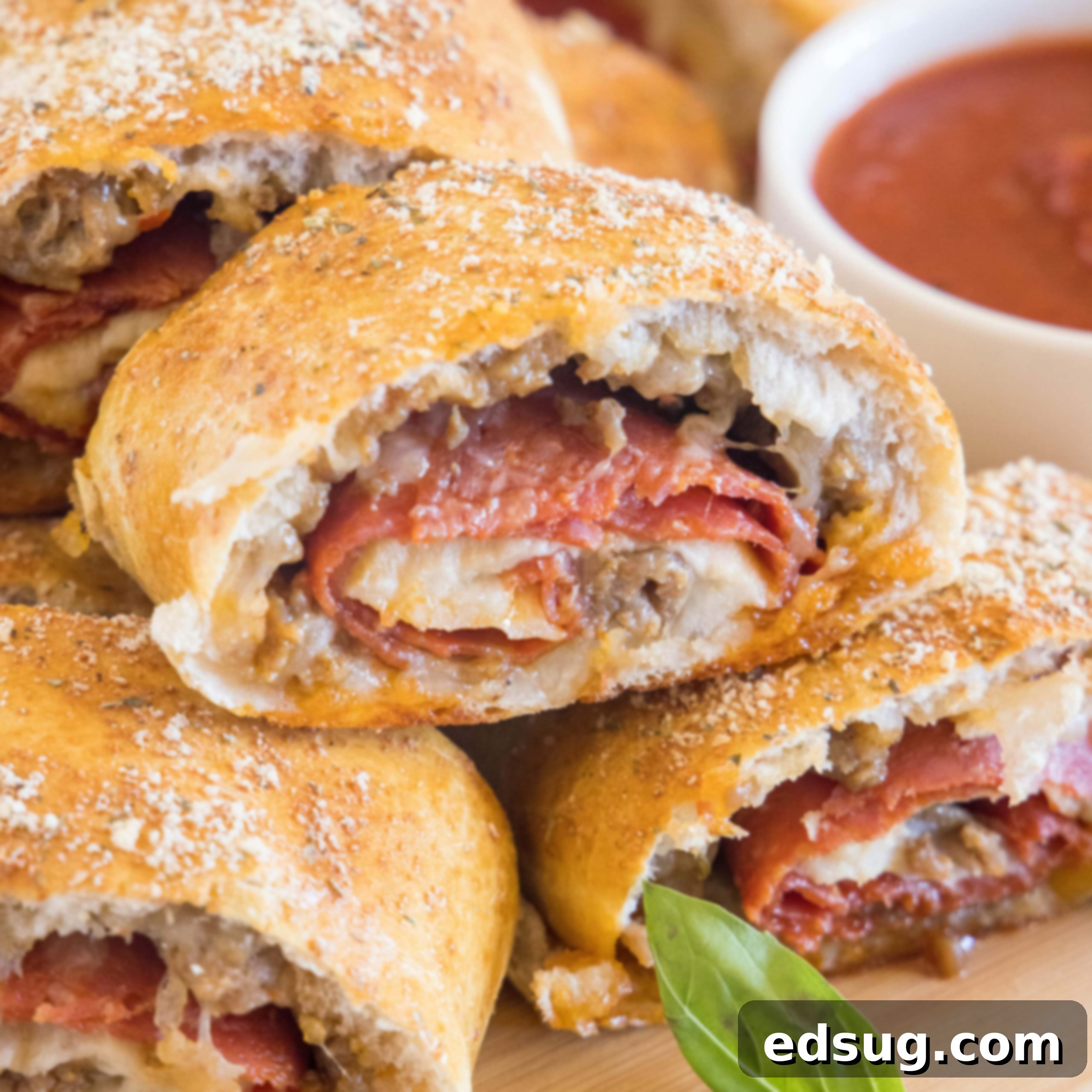 Kickoff Comfort Food 28 Pizza bread slices stacked on a wooden board next to a bowl of pizza sauce for dipping, showcasing melted cheese