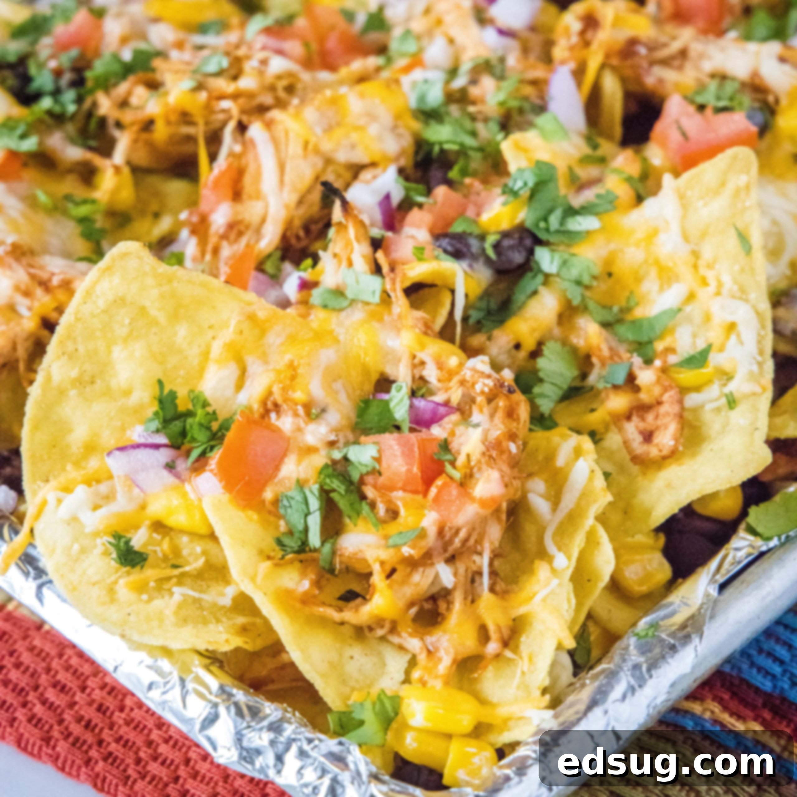 Kickoff Comfort Food 30 Close up of a plate of Barbecue Chicken Nachos, loaded with cheese and toppings