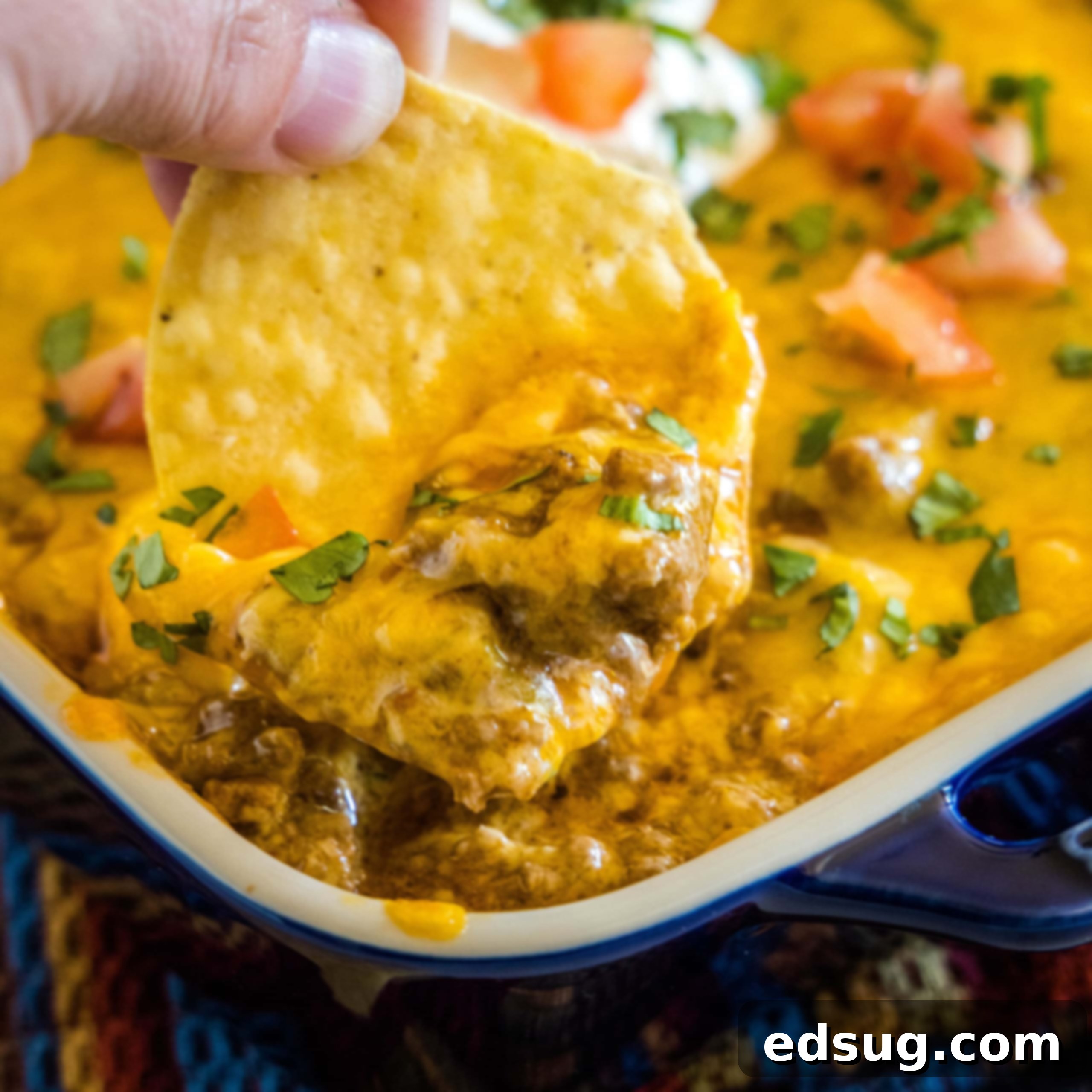 Kickoff Comfort Food 9 Close up of a chip scooping out Beef Enchilada Dip