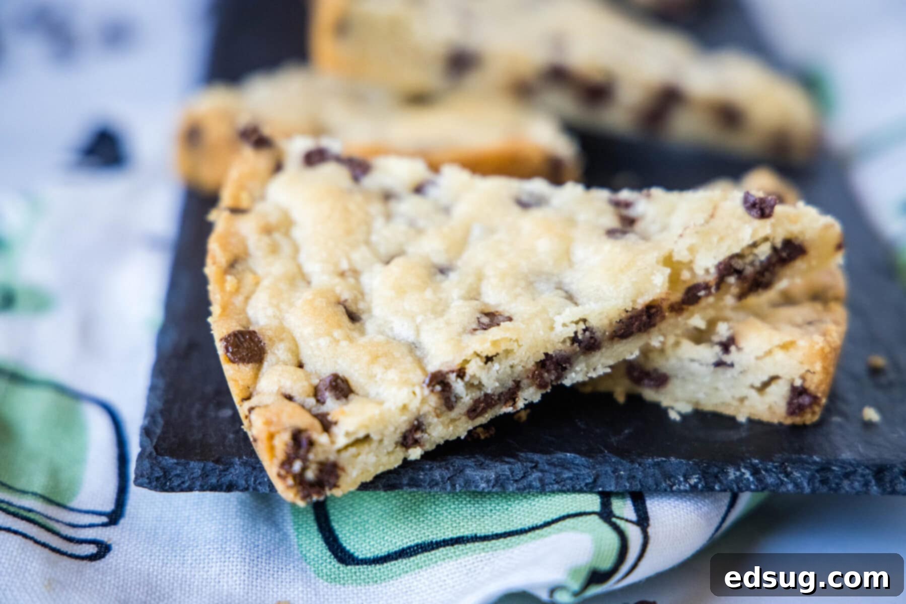Two pieces of chocolate chip shortbread on top of each other, with two pieces in the background.