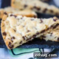 Close up of a triangle of chocolate chip shortbread, with more pieces in the background.