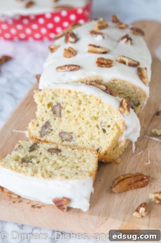 Maple Pecan Dream Loaf 2 A delicious slice of maple pecan loaf on a wooden board, showcasing its tender crumb and crunchy pecans.