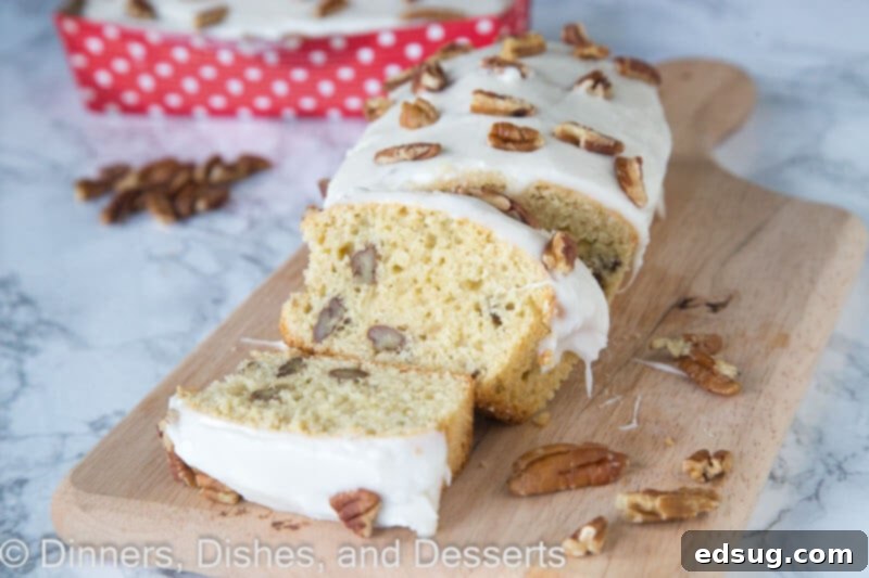 Maple Pecan Dream Loaf 4 A close-up shot of the fully baked maple pecan loaf, generously topped with maple frosting and extra chopped pecans, ready to be served.