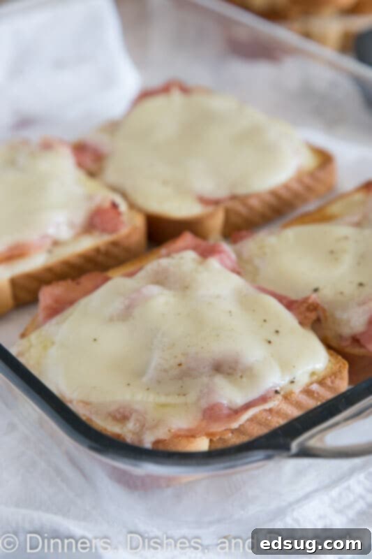 Uncovered Croque Monsieur 2 Four golden-brown open faced croque monsieur sandwiches arranged on a white plate, ready to be served.