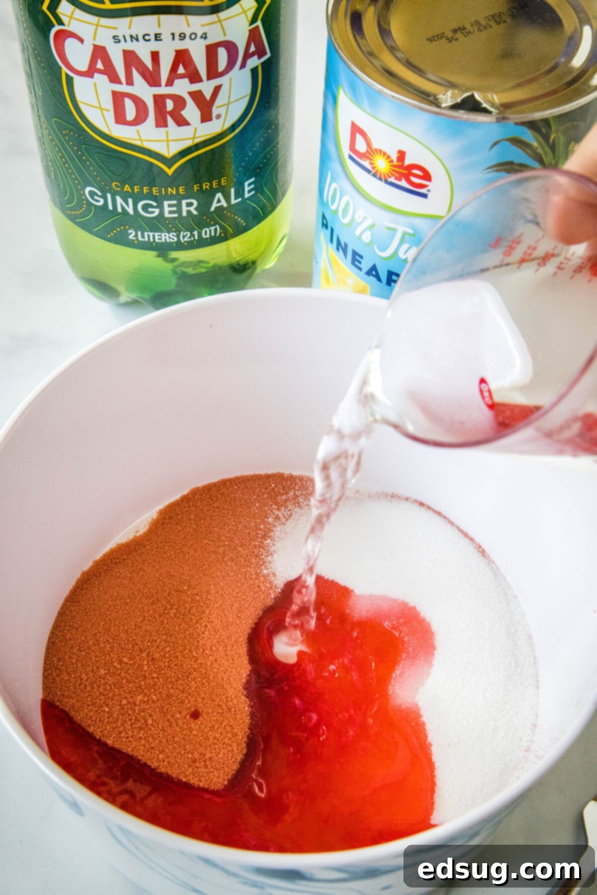 Festive Punch 4 Water being poured into a bowl of cherry Jell-O.