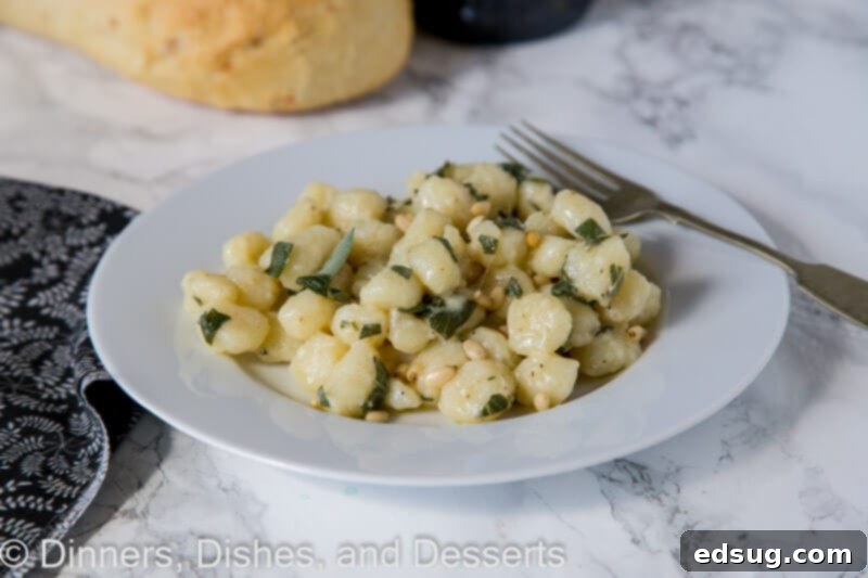 Pillowy Parmesan Gnocchi with Brown Butter Sage Sauce 3 Overhead shot of Parmesan sage butter gnocchi in a skillet with a wooden spoon, before serving.