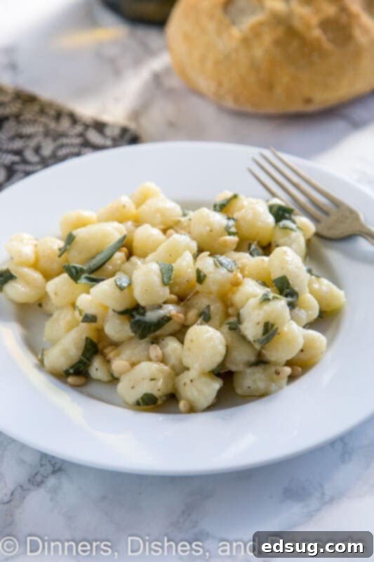 Pillowy Parmesan Gnocchi with Brown Butter Sage Sauce 4 A serving of Parmesan gnocchi with sage butter in a shallow bowl, showcasing its golden color and fresh sage leaves.