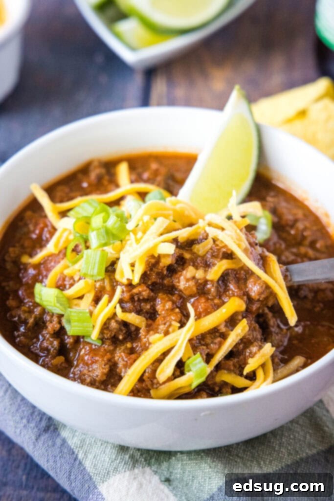 Rancher's Beef Chili 2 chili in a bowl with cheese on top and a spoon