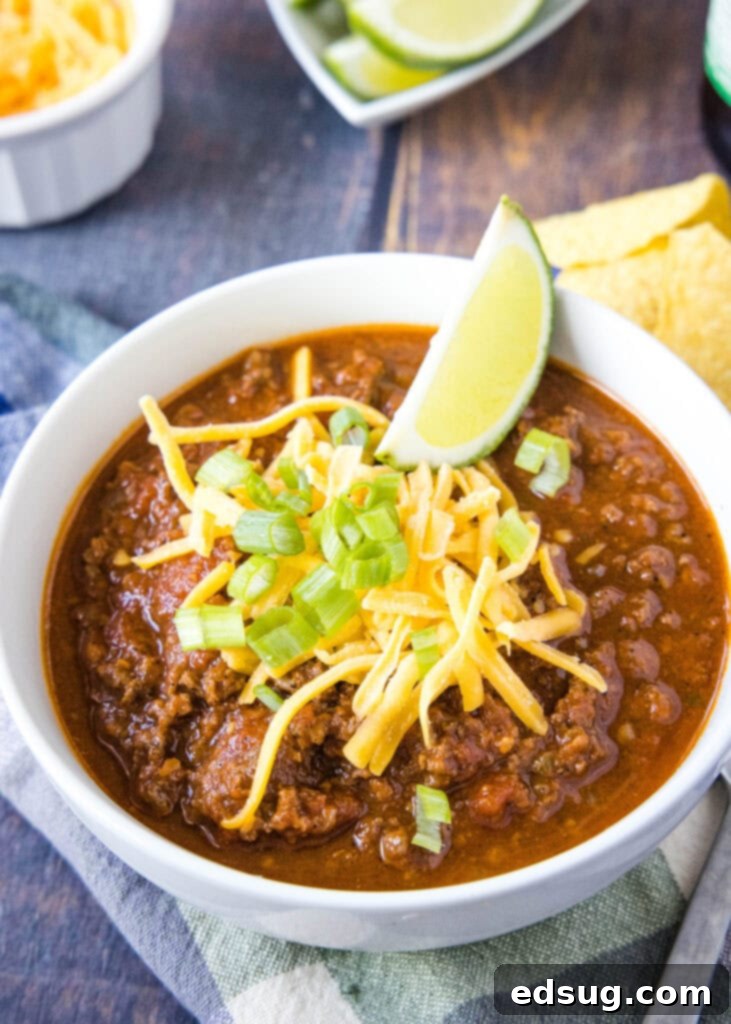 Rancher's Beef Chili 5 chili in a white bowl with cheese and green onions on top