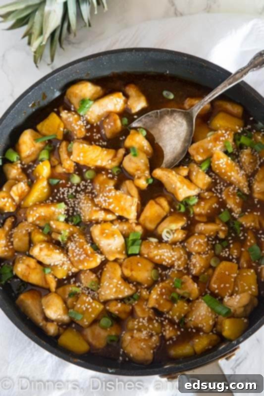 Tropical Pineapple Teriyaki Chicken 3 A serving bowl filled with a generous portion of Pineapple Chicken Teriyaki, garnished with green onions and sesame seeds, ready to be served.