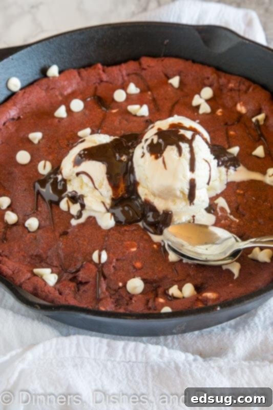 Decadent Red Velvet Skillet Cookie 3 Close-up of the vibrant Red Velvet Skillet Cookie in a cast iron pan, showing its rich red color and chocolate chips