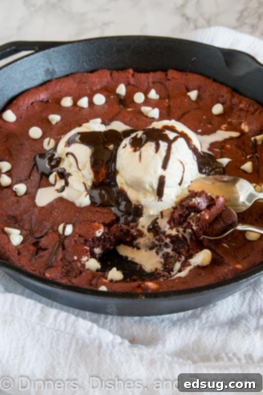 Decadent Red Velvet Skillet Cookie 4 Delicious Red Velvet Skillet Cookie with melted ice cream and hot fudge, ready to be eaten from the skillet