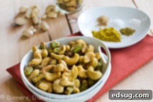 Indian Spiced Nuts in white bowl with plate of spices in background