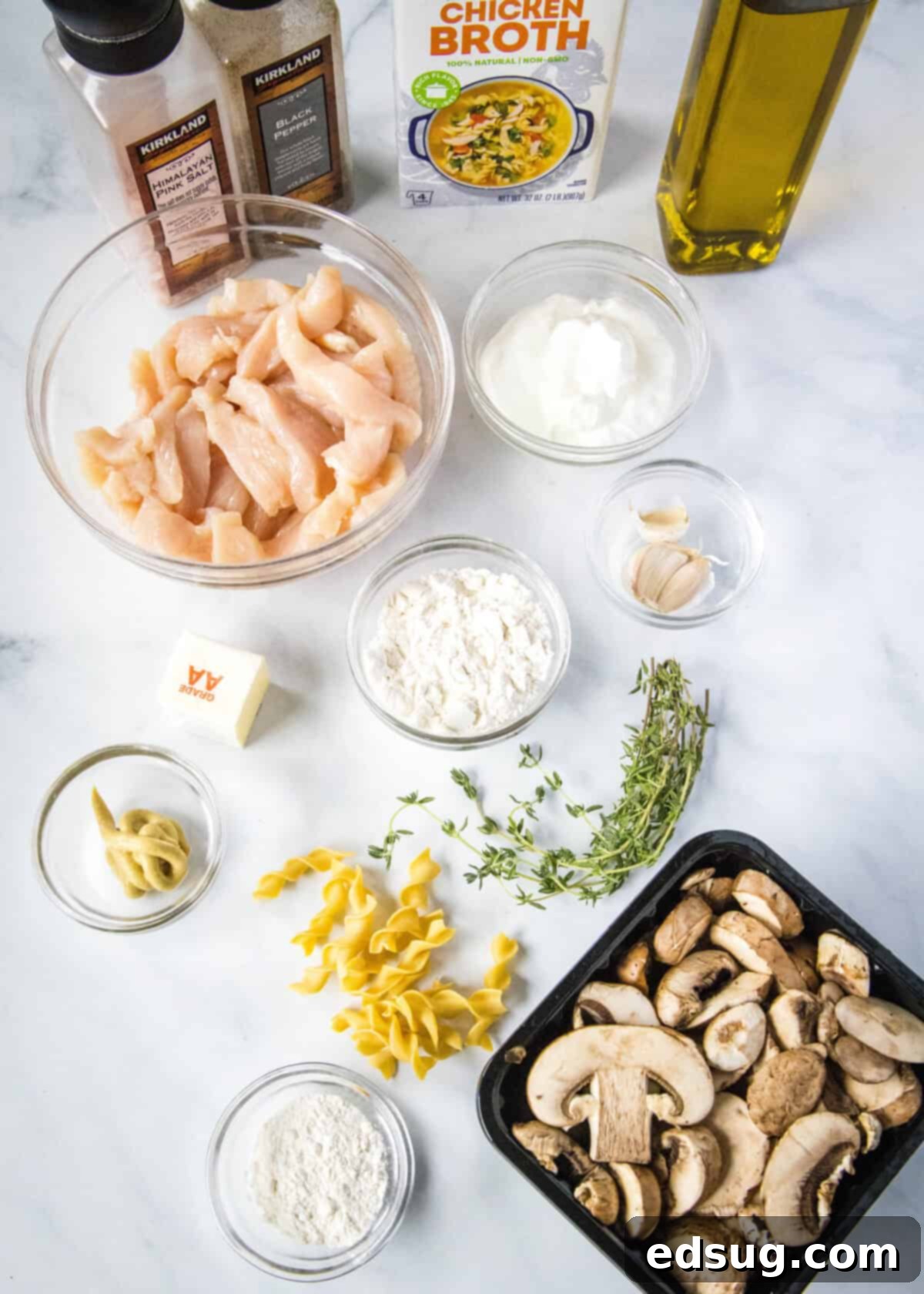 Velvety Chicken Stroganoff 3 Ingredients for Creamy Chicken Stroganoff laid out on a kitchen counter: chicken, mushrooms, broth, sour cream, and spices