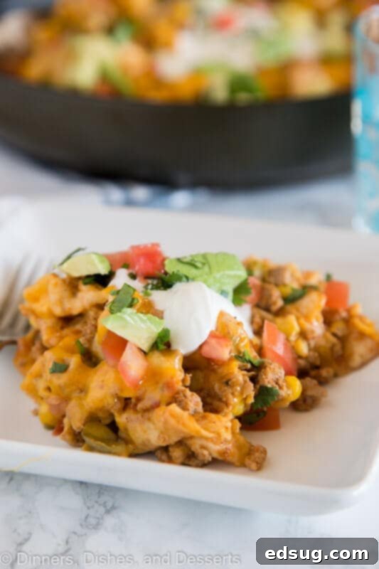 A plate of beef burrito skillet with sour cream and cilantro on top, ready to eat.