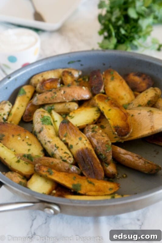 A rustic bowl filled with Pan-Seared Mojo Potatoes, featuring crispy edges and bright green cilantro, ready to be served.