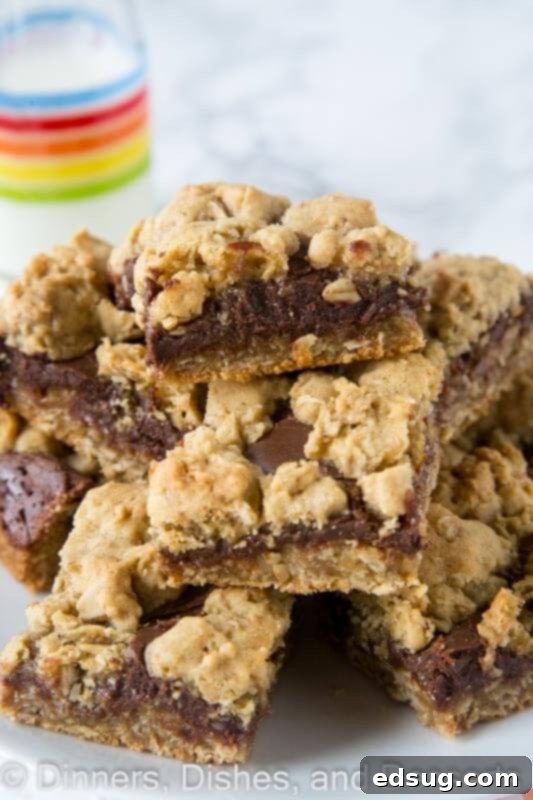 Stacked Oatmeal Fudge Bars on a plate, showcasing chewy cookie layers and a thick fudge center