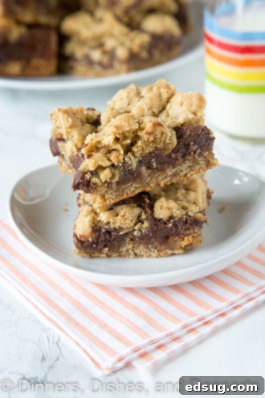 Close-up of a stack of Oatmeal Fudge Bars showing the distinct layers of oatmeal cookie and chocolate fudge