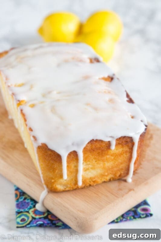 Sunshine Lemon Ricotta Loaf 2 A beautifully glazed loaf cake, sliced and ready to serve, sitting on a cutting board, highlighting its moist texture and vibrant lemon flavor.