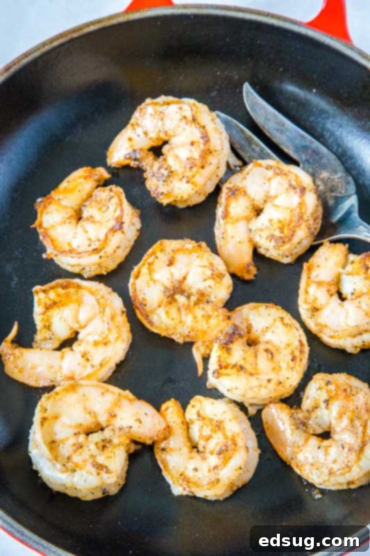 Cooked seasoned shrimp sizzling in a skillet