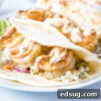 Baja shrimp tacos on a white plate, ready to be enjoyed.
