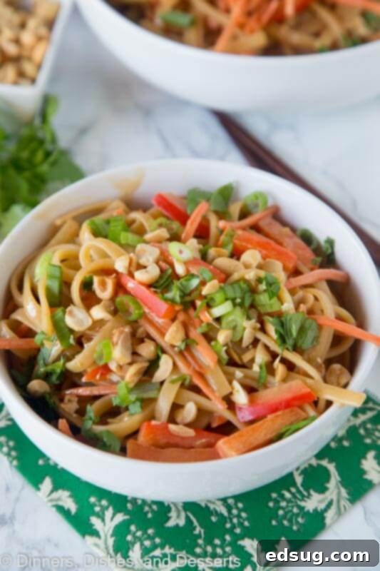 A vibrant bowl of Thai Peanut Noodles with bell peppers, carrots, and a creamy sauce