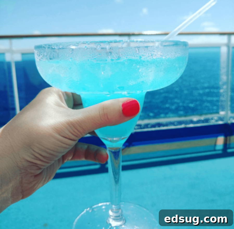 The Quintessential Lime Margarita, On the Rocks 6 A vibrant blue margarita garnished with a fresh lime slice, offering a fun and colorful twist on the classic cocktail.